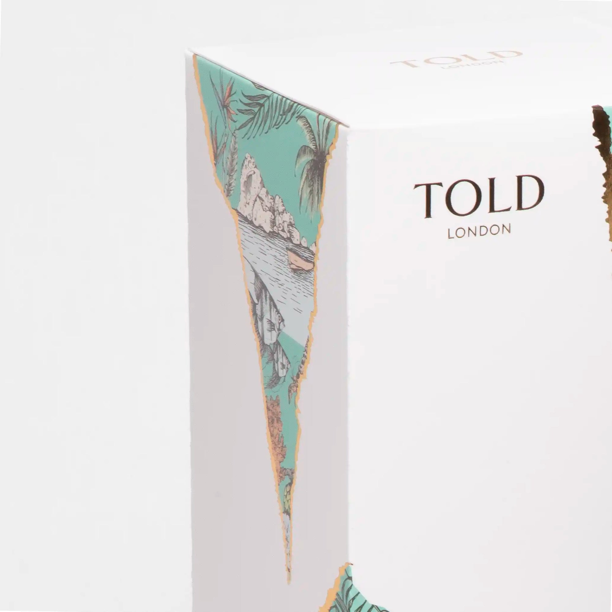 A close up of Told London white box packaging featuring the strips of wallpaper which feature illustrations of the location and gold Told London logo