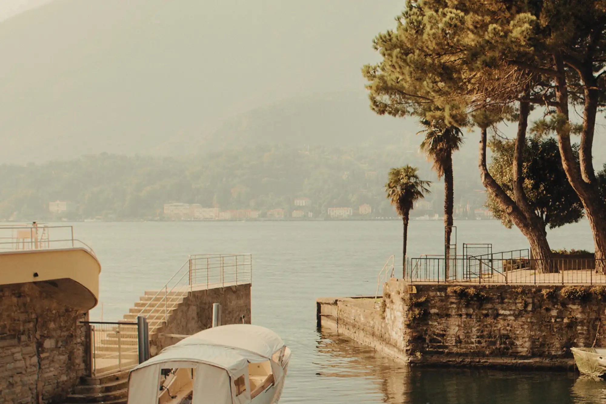 Lake como with a boat and villas on the shoreline in the distance 