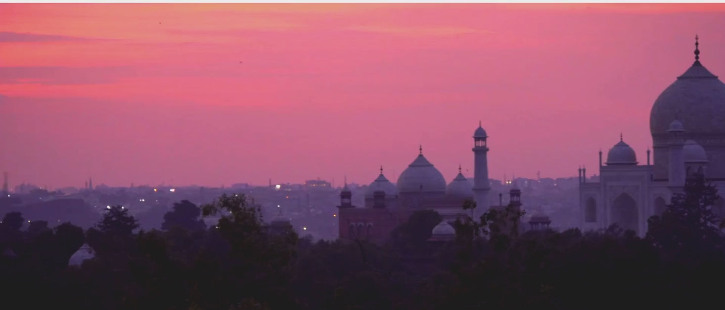 Camera pan of the Taj Mahal against a red sky