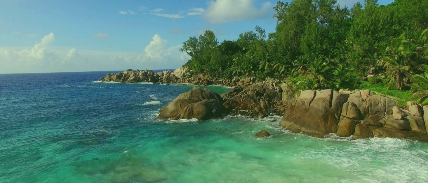 Camera zooms out from a rocky shoreline in the seychelles